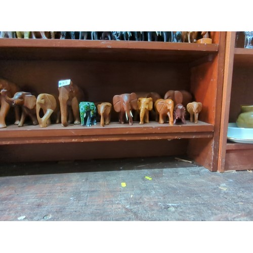 871 - A quantity of carved elephant figures, various sizes and timbers, including examples with painted de... 