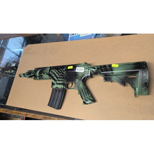 599 - AR-style airsoft rifle with green-and-black camouflage finish, polymer adjustable stock, railed hand... 