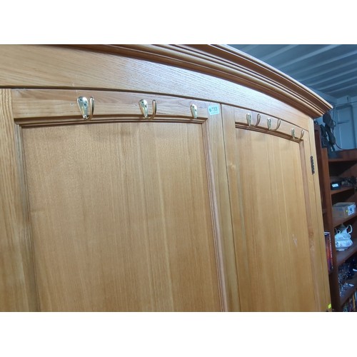 212A - Contemporary wardrobe, the arched cornice above two panelled doors with turned wooden knobs and a ro... 