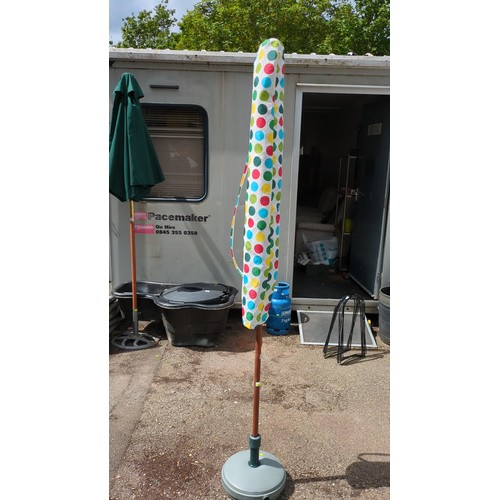 95 - Garden parasol with multicoloured polka-dot canopy, accompanied by a grey weighted base and a matchi... 