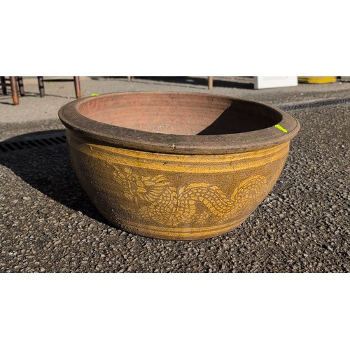59B - Large moulded terracotta jardinière of wide circular form with thick rolled rim, painted with ochre... 