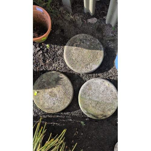 59d - A group of three cast stone garden stepping stones of circular form, each moulded in relief with flo... 