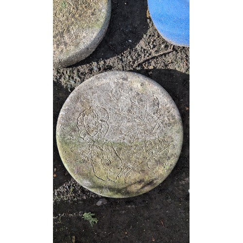 59d - A group of three cast stone garden stepping stones of circular form, each moulded in relief with flo... 