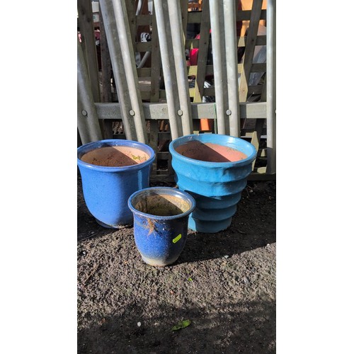 59e - A set of three glazed terracotta planters, including two cylindrical pots and a stepped, banded plan... 