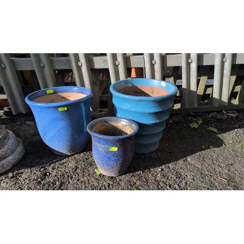 59e - A set of three glazed terracotta planters, including two cylindrical pots and a stepped, banded plan... 