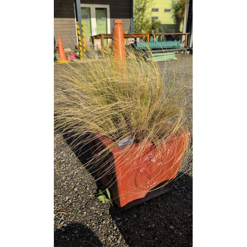 90a - Concrete garden planter, painted red, the sides with a raised circular wreath medallion; planted wit... 