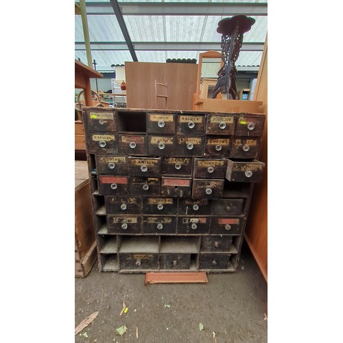 Late 19th/early 20th century French apothecary’s multi-drawer cabinet in stained softwood, the façade fitted with assorted small drawers and open compartments, many with painted spice labels and faceted clear-glass pulls.