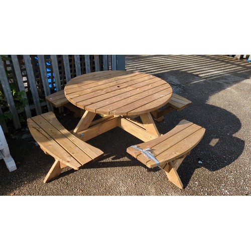 Circular slatted pine picnic table with integral wraparound benches, the top pierced for a parasol, on A-frame supports with bolted cross-stretchers.