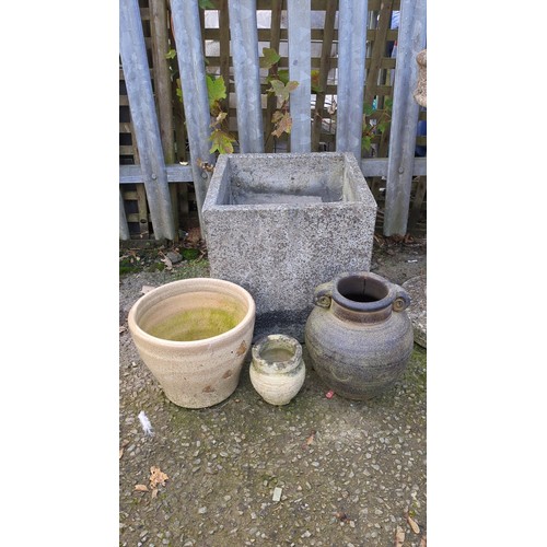 Four garden planters comprising a large square cast-stone planter, a ...