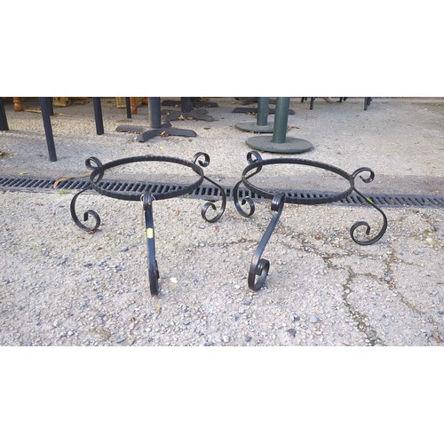 A pair of black-painted wrought-iron jardinière stands, each with a ...