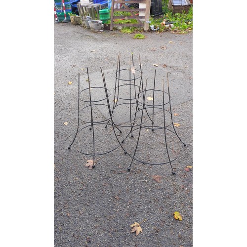 Three black-painted metal garden plant supports of open conical form ...