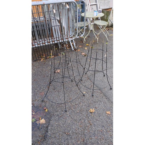 Three black-painted metal garden plant supports of open conical form ...