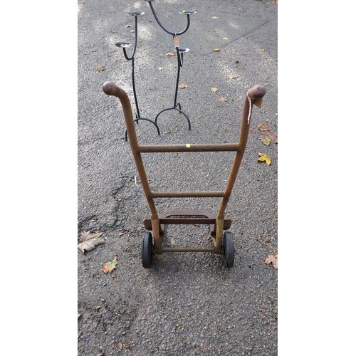 Steel sack truck with a tubular frame, curved handgrips, transverse ...
