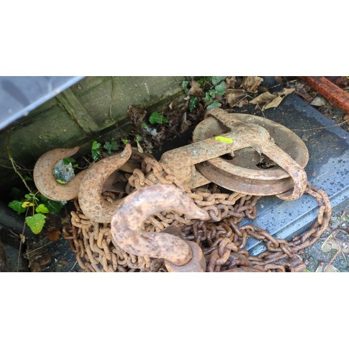 A group of heavy iron lifting pulley blocks with large hooks, open ...