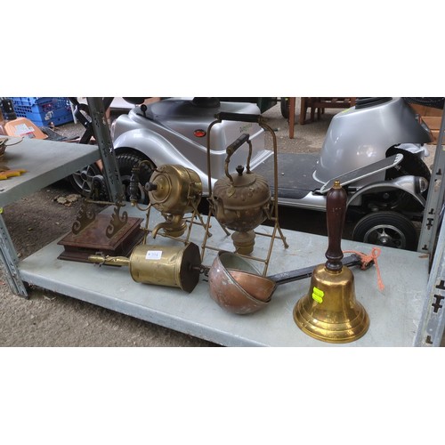 Lot 394: A group of brass and copper domestic wares, including two tilting kettles on stands, a handbell with turned wooden handle, a copper scoop, a cylindrical brass apparatus and a brass-mounted wooden rack.