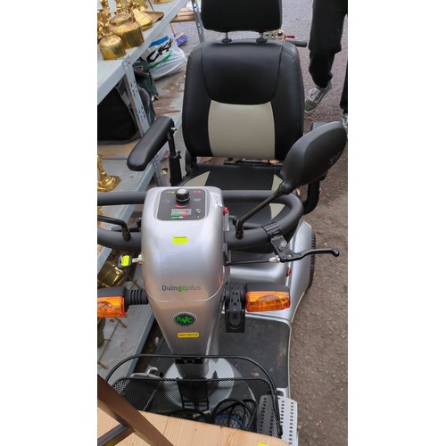 Lot 450: Quingo Plus five-wheel electric mobility scooter in silver, with black and cream upholstered seat, adjustable armrests, tiller-mounted controls, indicators, front basket and charger.
