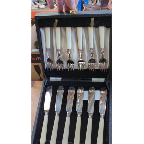 A group of cased silver-plated table and serving utensils, including ...