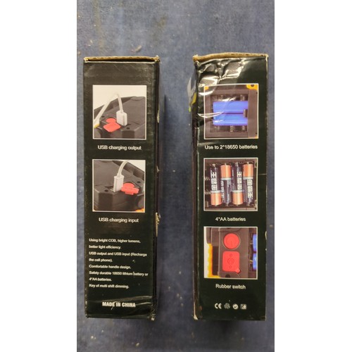A pair of boxed multifunctional COB LED work lamps, with orange-and ...