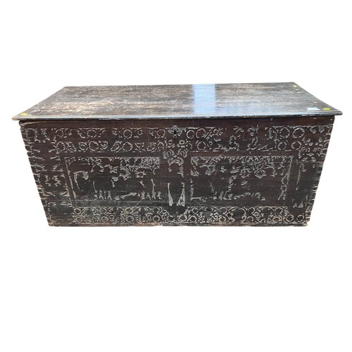 Lot 449: Wooden blanket chest, possibly Italian, with a hinged plank lid, dovetailed corners and iron ring handles; the front decorated with foliate scrollwork and framed woodland scenes with animals.