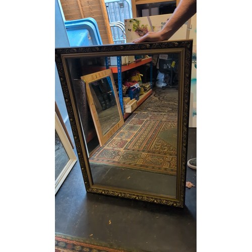 Rectangular wall mirror in a black and gilt frame, the broad border ...