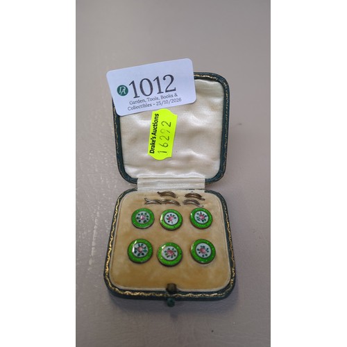 A set of six enamel dress buttons, each centred by a pink rose on a ...