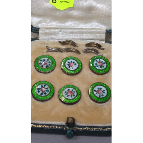 A set of six enamel dress buttons, each centred by a pink rose on a ...