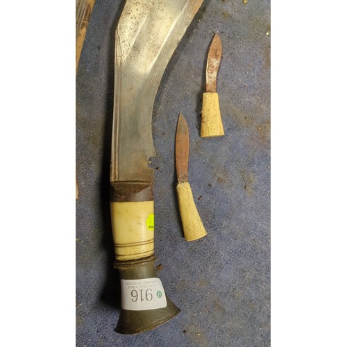 Kukri with a broad, inward-curving steel blade, pale grip and flared ...