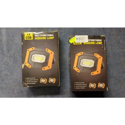 A pair of boxed multifunctional COB LED work lamps, with orange-and ...