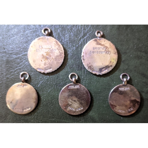 119 - Medallions; five sterling silver Eisteddfod medallions - three identical Kingswood & District, and t... 