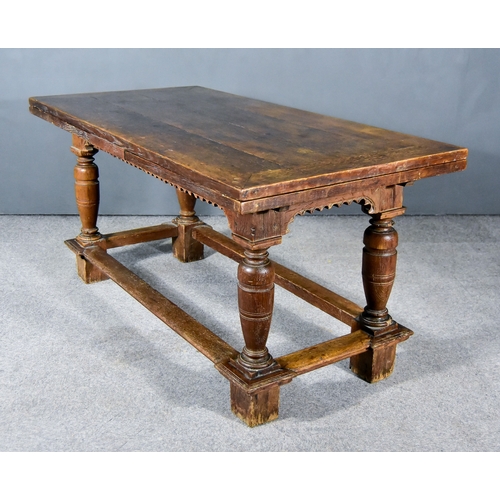 257 - An Old Oak Continental Draw Leaf Extending Dining Table, with four plank cleated top, carved frieze ... 