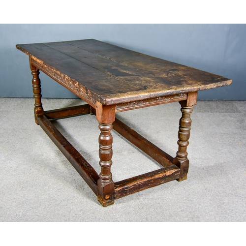 263 - An Old Oak Refectory Table, with three plank cleated top, the frieze carved with scrolling floral or... 