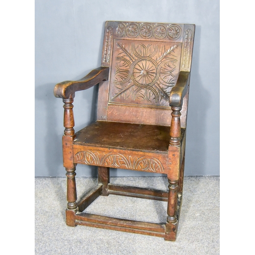 264 - A 17th Century Panelled Oak Arm Chair, the crest rail carved with stylised floral patera, flanked by... 