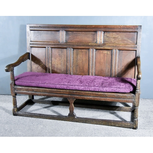 267 - A 17th Century Panelled Oak Settle, with moulded rails and eight fielded panels to back, outscrolled... 