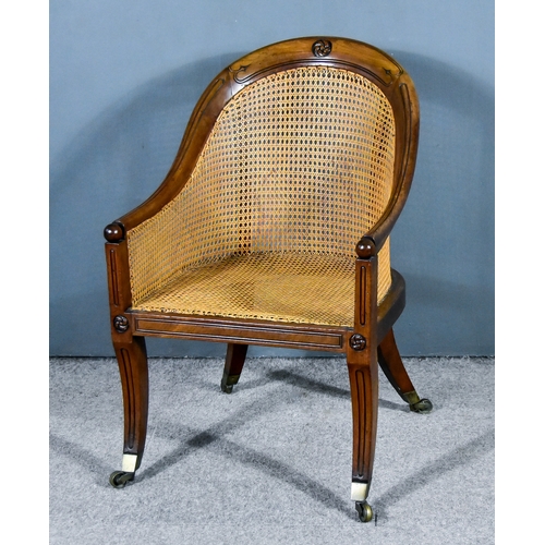 307 - An Early 19th Century Mahogany Framed Bergere Easy Chair, the tub-shaped back with leaf cresting, ca... 