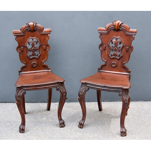 317 - A Pair of Victorian Figured Mahogany Hall Chairs, each with shaped and moulded crest rails, fretted ... 