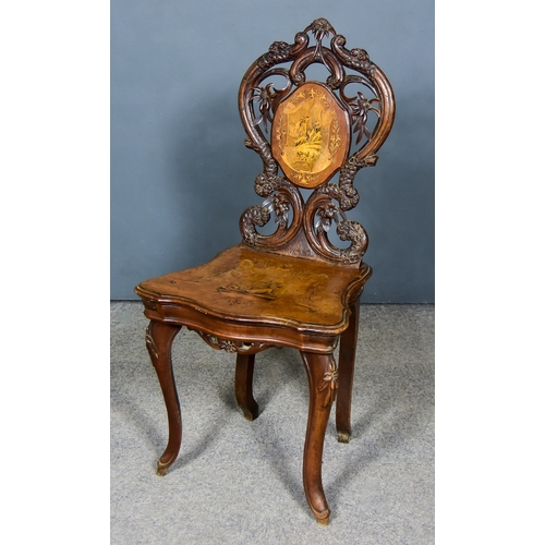 321 - A Swiss Walnut Musical Chair, 19th Century, with bold leaf and fretted carved back of shaped outline... 