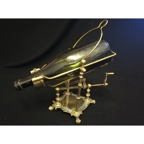 24 - Antique brass mechanical wine bottle pourer with pad feet (bottle not included) - height 14½