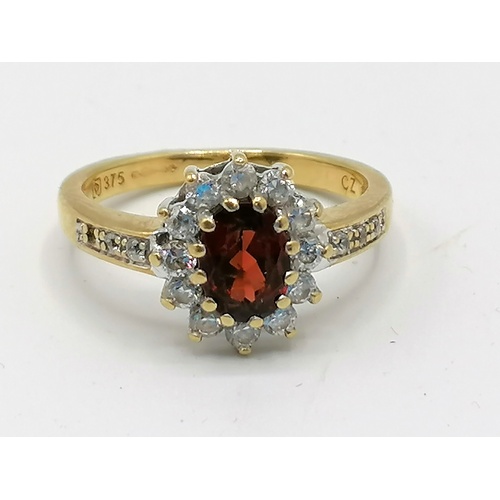 240 - 9ct gold garnet & CZ cluster ring with stones set in shoulders - 1 stone missing in shoulder