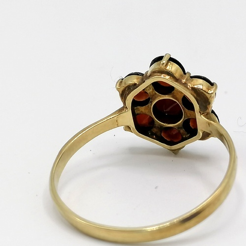 303 - 8ct gold (333) garnet flower shaped ring