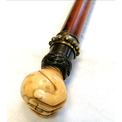 627 - Malacca walking cane with an antique ivory hand holding a ball with a metal mount