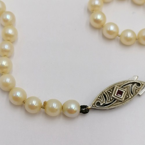 250H - 9ct white gold ruby set clasped strand of pearls (16½