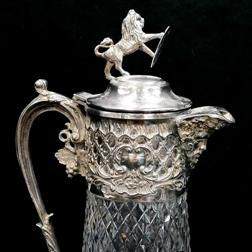 507 - Silver plated on copper claret jug with lion holding a shield finial - 33cm high