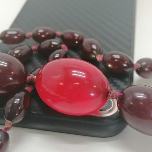 218 - Strand of cherry amber beads, 68cm length, 53g in weight (needs restringing)  - SOLD ON BEHALF OF TH... 