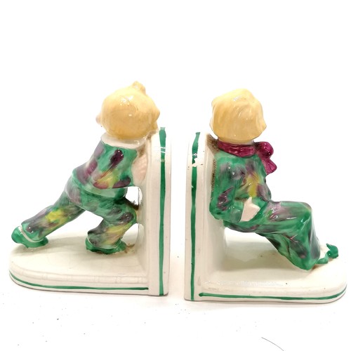 25 - Pair of Art Deco china bookends children at play, 12cm high. Some crazing to both and chips to paint... 