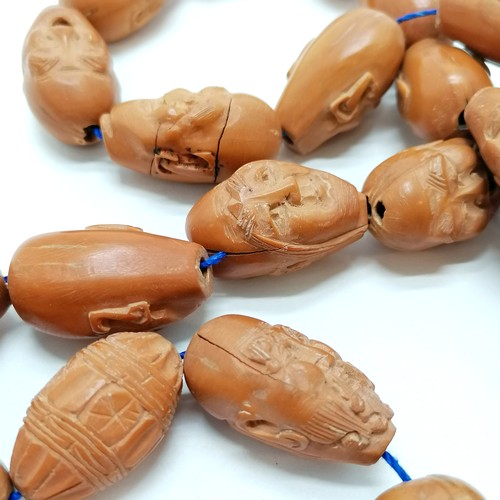 474 - Strand of 26 hand carved wooden beads mostly depicting facial expressions - approx length of bead 2.... 