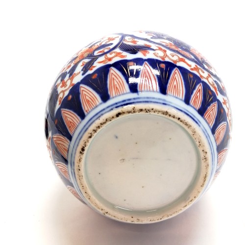 11 - Imari jar and associated cover (with chips) on an oriental wooden stand (16cm diameter)