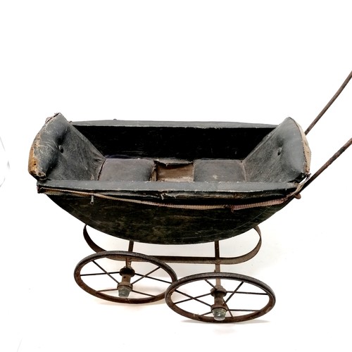 57 - Antique black painted dolls pram, handle cracked and upholstery needs attention, 68cm long x 64cm hi... 