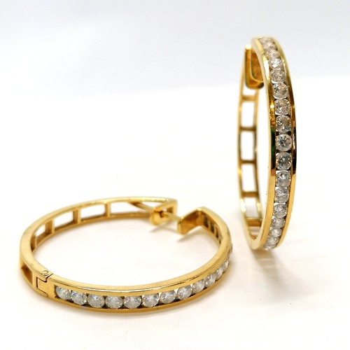 117 - Pair of unmarked yellow gold (touch tests as 18ct or higher) hoop earrings channel set with 18 diamo... 