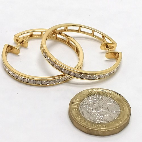 117 - Pair of unmarked yellow gold (touch tests as 18ct or higher) hoop earrings channel set with 18 diamo... 