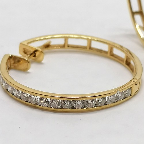 117 - Pair of unmarked yellow gold (touch tests as 18ct or higher) hoop earrings channel set with 18 diamo... 